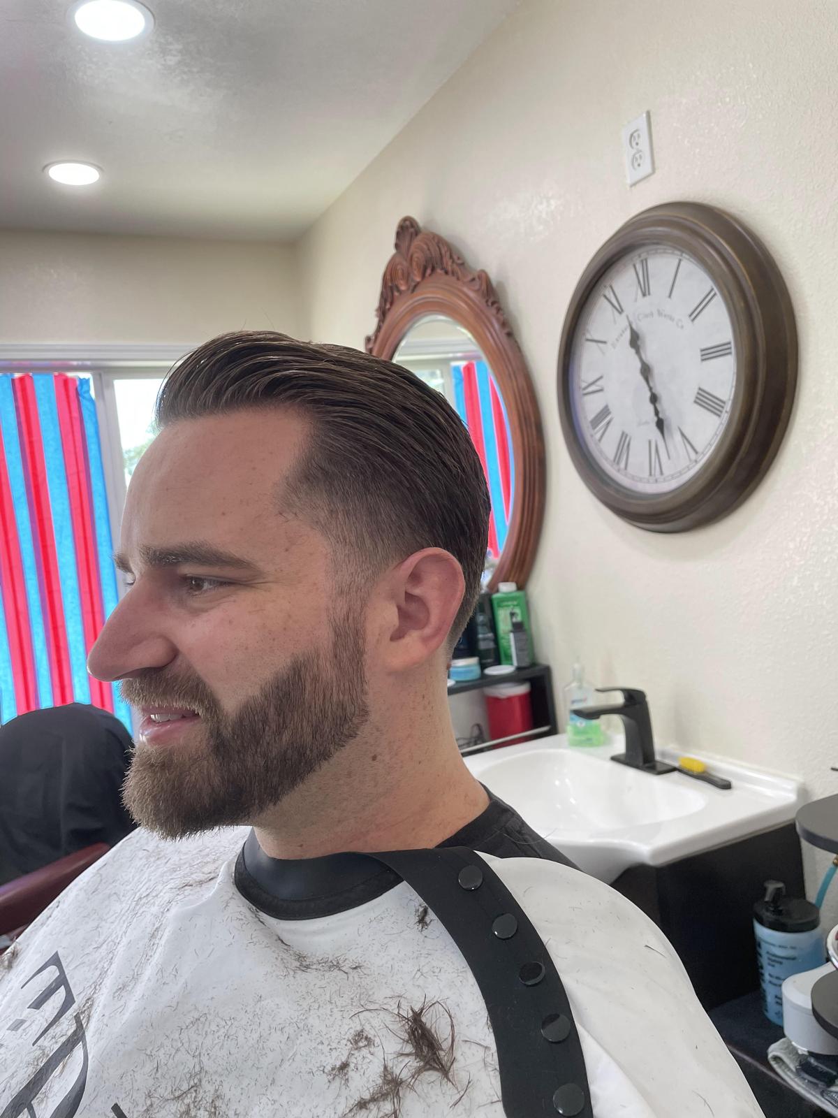 Client with a fresh side-part pompadour and beard shape-up