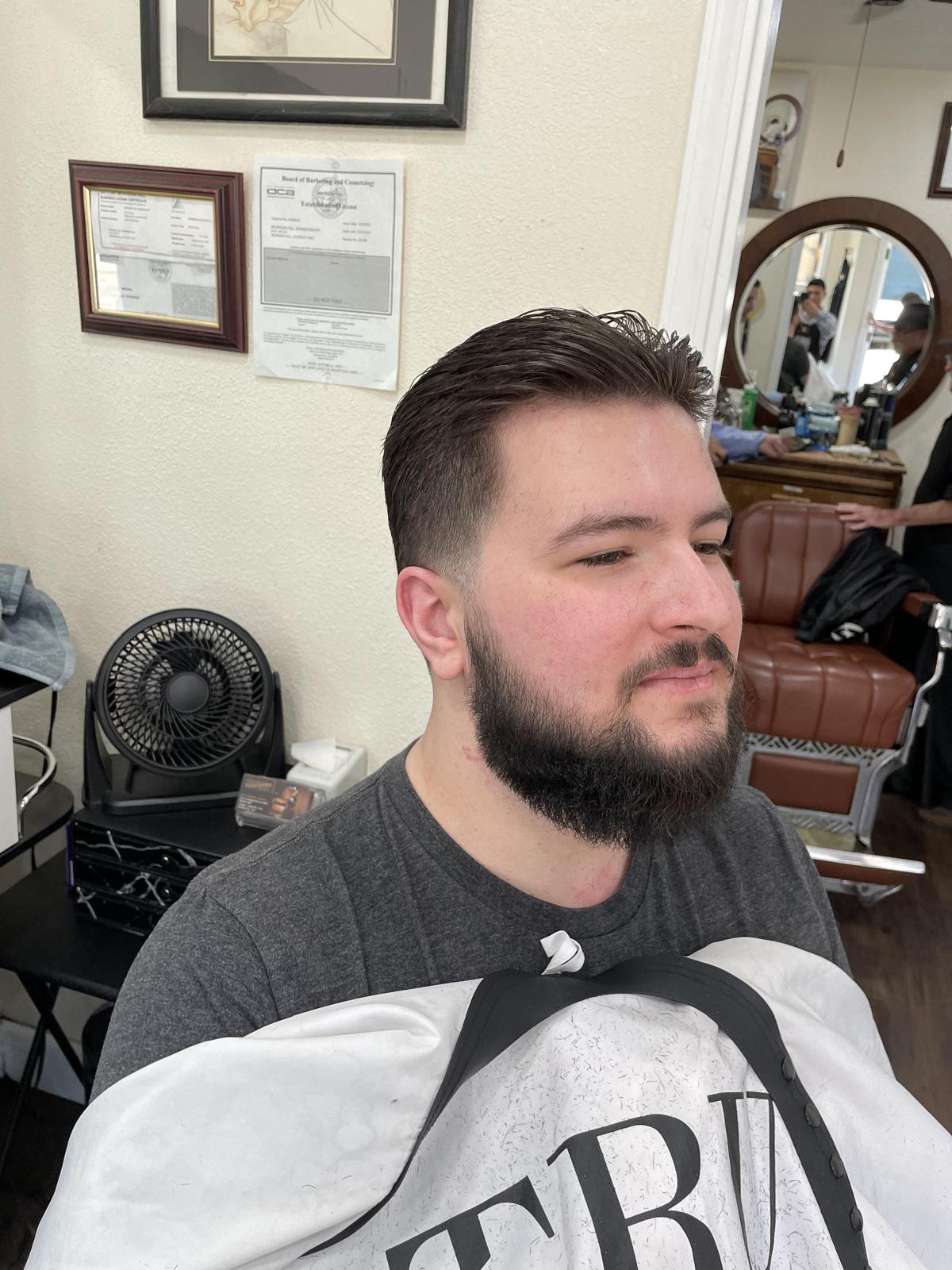 Client with a clean taper fade and full beard trim