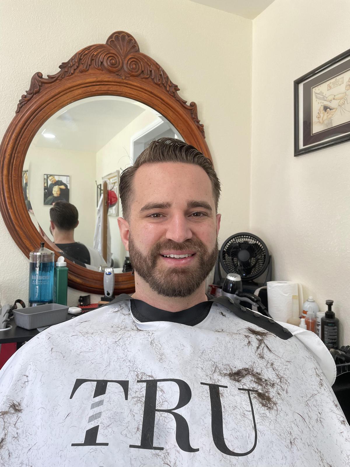 Smiling client after a classic haircut and beard line-up