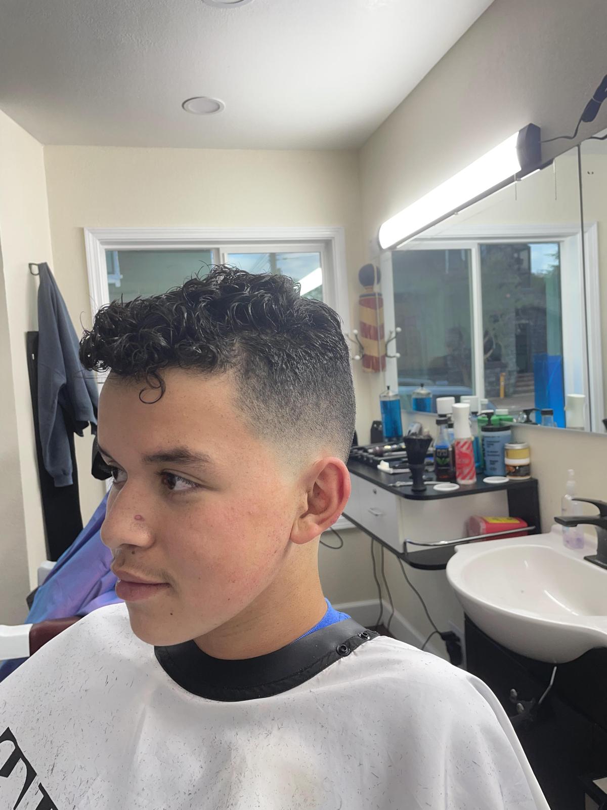 Young client with a curly top and skin fade
