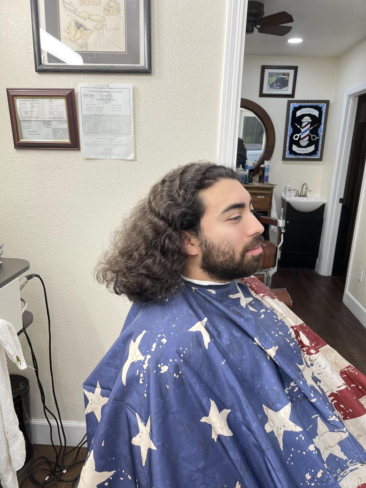 Client with long curly hair and a full beard before styling